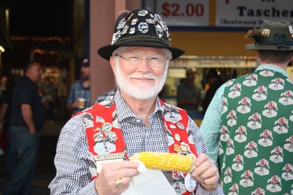 A cheery Wurstfest opa enjoys one of the healthier festival food options. (Ian Pribanic/Community Impact Newspaper)