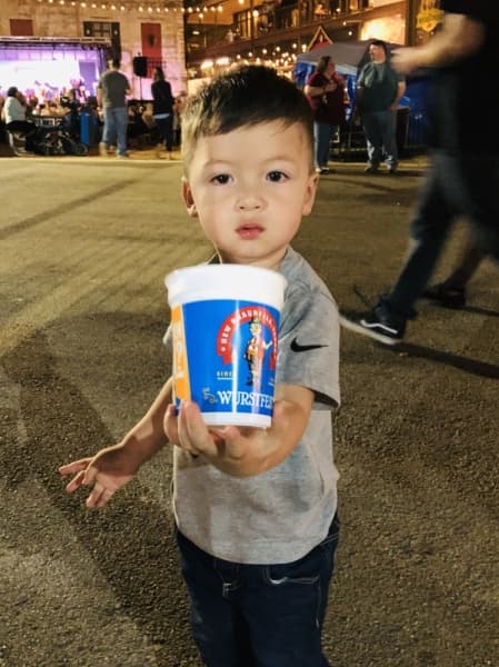 A young festivalgoer enjoys a stroll by the Comal River on the grounds of Wurstfest. (Ian Pribanic/Community Impact Newspaper)