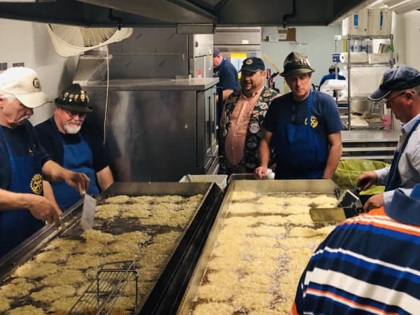 Members of the New Braunfels Rotary Club fry up a batch of potato pancakes. (Ian Pribanic/Community Impact Newspaper)