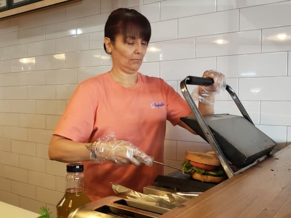 Michele Travis makes a Boar's Head sandwich. (Ali Linan/Community Impact Newspaper)