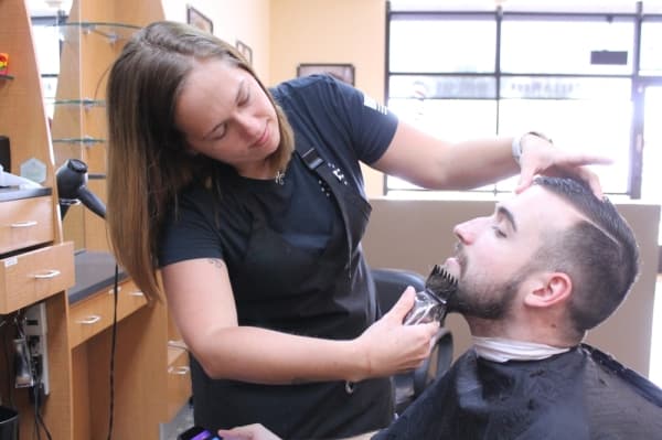 Shirley trims a customer's beard. (Lindsey Juarez Monsivais/Community Impact Newspaper)