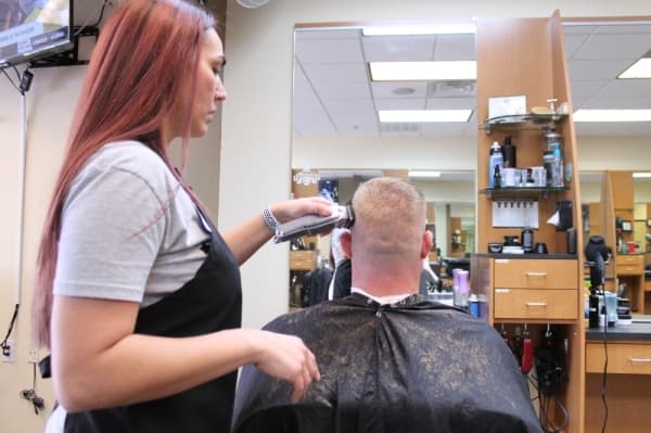 Bronson evens out the haircut on a customer. (Lindsey Juarez Monsivais/Community Impact Newspaper)