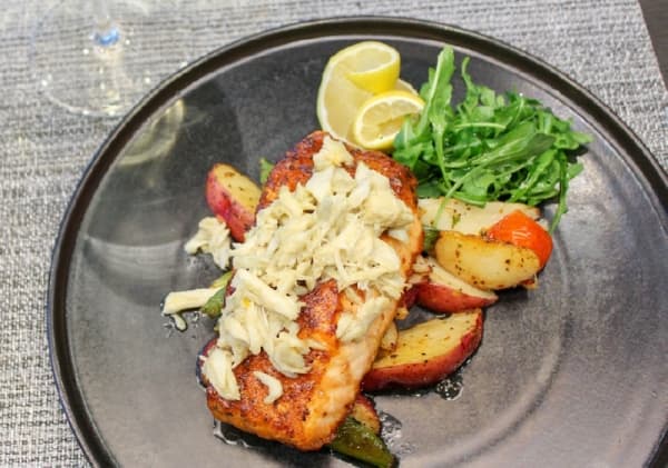 The Pan-Seared Verlasso Salmon ($28) comes with a raspberry and chipotle glaze, butter-poached crabmeat and roasted potatoes. (Adriana Rezal/Community Impact Newspaper) 