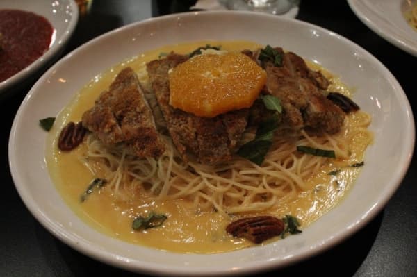 The pecan-crusted chicken ($15.50) is served on a bed of angel hair pasta in an orange basil cream sauce. (Photo by Anna Herod/Community Impact Newspaper)
