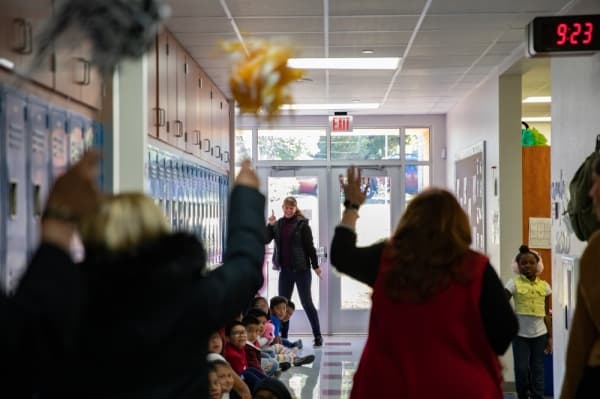 Third grade teacher Ellen Nagoski begins dancing in celebration as the Grant Patrol approaches. Her grant will go toward speaking centers to encourage parent engagement and increased language skills.