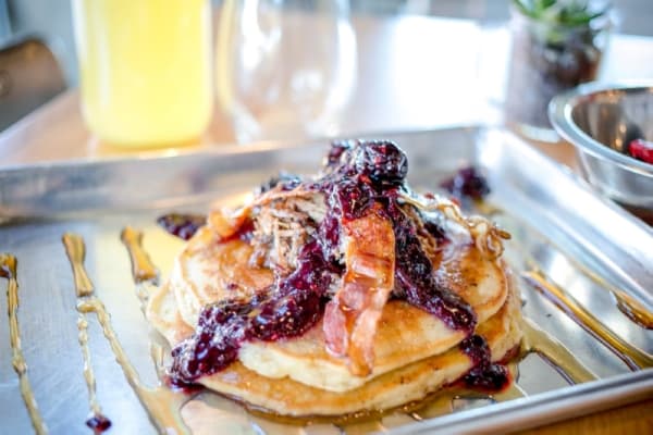 Porkey's Pancakes: Buttermilk pancakes are smothered in pork pastor, bacon, blackberry compote and bourbon maple syrup. (Courtesy Industry)