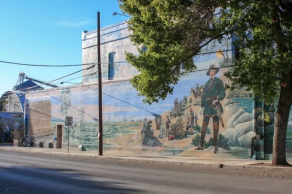  “City of a Prince”
Location: West San Antonio Street and Castell Avenue, New Braunfels 
Subject: “City of a Prince” was the first mural painted in New Braunfels and depicts the arrival of Prince Carl of Solms-Braunfels in Texas on July 1, 1844, when he purchased 1,265 acres on the Guadalupe River. Then, on March 21, 1845, German immigrants arrived and marked the founding of New Braunfels, the first Texas colony of German settlers. 
Artist: Clinton Baermann 
Dedication date: March 21, 1999 
Price: $25,000 
