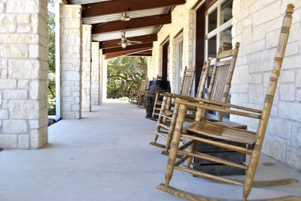 In addition to indoor seating, 5 Stones Artisan Brewery has a wrap-around porch and outdoor tables under shady trees. (Chelsea Bagley/Community Impact Newspaper)