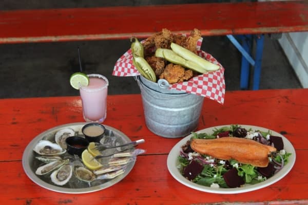 According to managers, some of Lucy Fried Chicken’s best sellers include: (clockwise from top right) bucket o’ chicken, ruby red trout salad, raw oysters and a juicy lucy.
BRIAN PERDUE/COMMUNITY IMPACT NEWSPAPER