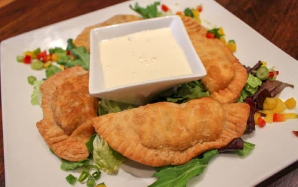 Empanadas don pedro ($14) are four Argentinian-style empanadas filled with chicken, beef, shrimp or vegetables and served with a basil cream sauce. (Kara McIntyre/Community Impact Newspaper)