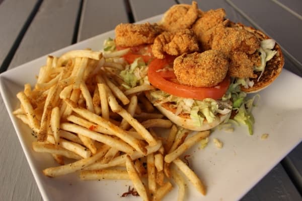 The Shrimp Po'Boy ($12.99) features fried shrimp atop a bed of lettuce and tomatoes, served on a hoagie with a side of fries.
