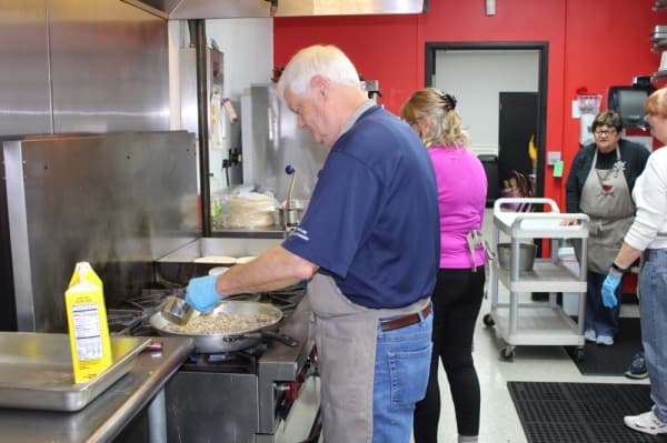 Volunteers help cook lunch for the community. (Photo by Anna Herod/Community Impact Newspaper)
