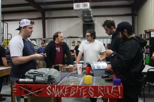 A group of customers browse trading cards for sale at Atomic Hobby Shop.