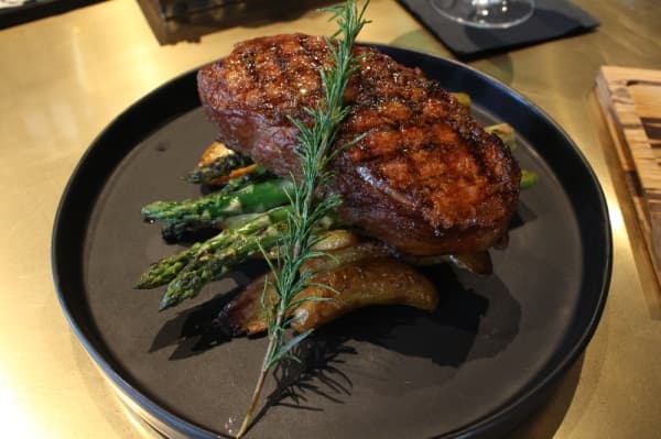 The New York Strip entree comes with asparagus and herb potatoes. (Elizabeth Ucles/Community Impact Newspaper)