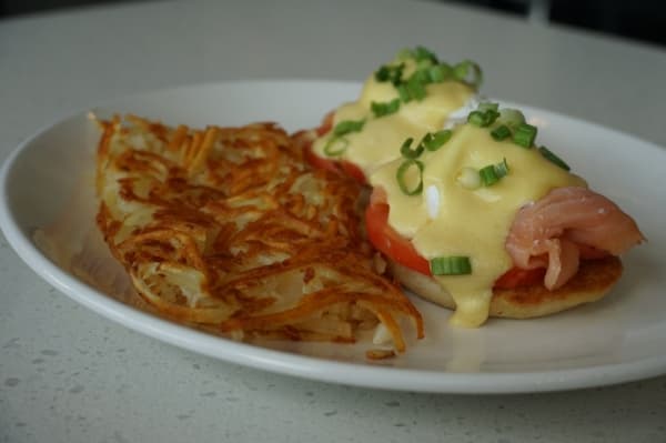 Smoked salmon ($12.99) comes with poached eggs, sliced salmon lox, tomatoes, cream cheese and toppings of hollandaise and capers. (Gavin Pugh/Community Impact Newspaper)