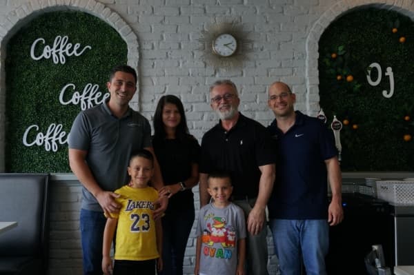 Brian Asani (left) and Raymond McGaw (right) run the Frisco location. Meff Asani (second from right) runs the McKinney location. (Gavin Pugh/Community Impact Newspaper)