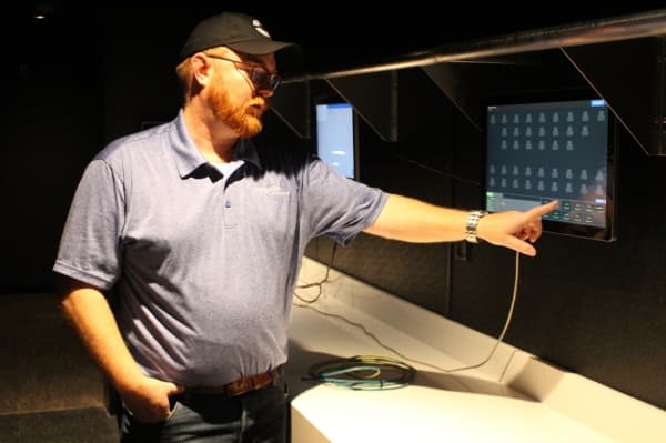 Barrett Cox demonstrates electronic system work guests use to request a server. Photo  Andrew Christman/Community Impact Newspaper