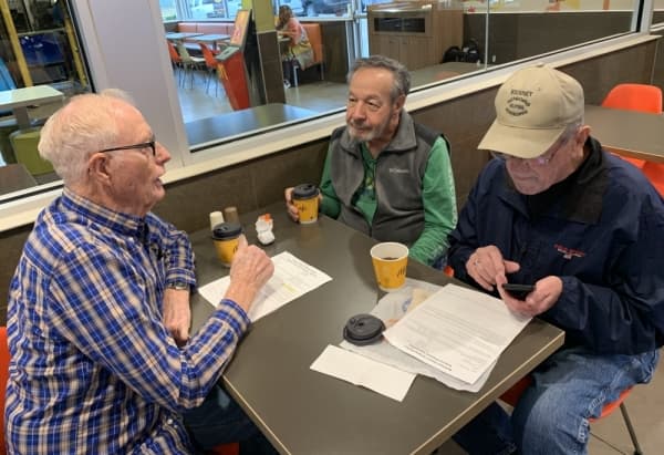 Lewis Reichert, Ted Wilson and Dick Baker plan for the day's projects in their makeshift office at McDonald's. Seniors Helping Seniors meets there every Wednesday morning to go over work orders and get assignments. (Jean Ann Collins/Community Impact Newspaper)