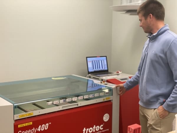 Connor O'Reilly, director of laser craft for Wexel Art, operates the Speedy 400, the company's high-performance laser cutter.
