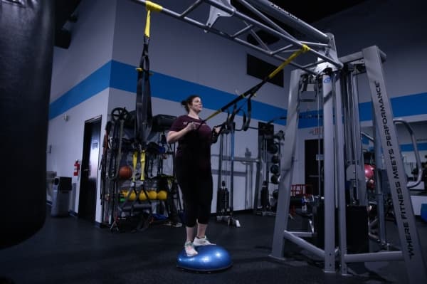 Lindy Langston performs a TRX row exercise as part of her one-on-one training session. (Liesbeth Powers/Community Impact Newspaper)
