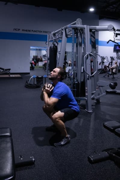 ProCore Fitness trainer Tony West does an example set of goblet squats. (Liesbeth Powers/Community Impact Newspaper)