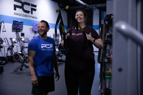 Trainer Tony West encourages Lindy Langston through a series of TRX rows during their one-on-one training session. (Liesbeth Powers/Community Impact Newspaper)