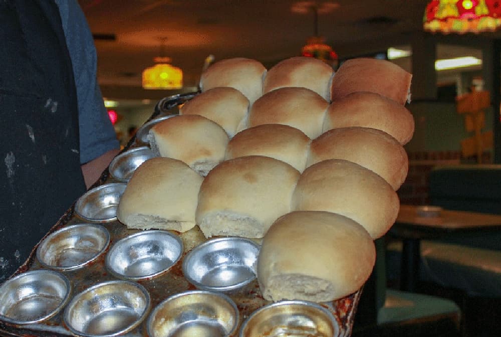 A designated roll thrower walks throughout the restaurant tossing homemade rolls to patrons upon request. (Hannah Zedaker/Community Impact Newspaper) 