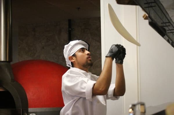 Chef tosses pizza dough