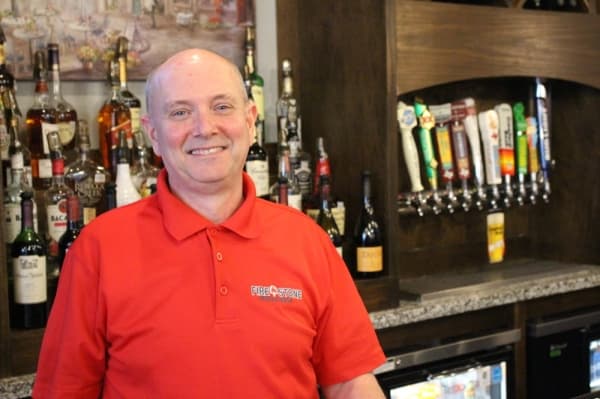 Owner in front of bar 