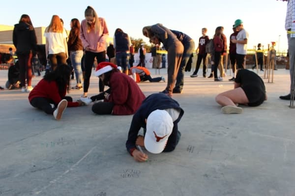 Carroll ISD students and supporters sign the slab of the upcoming new music center Dec. 11. (Miranda Jaimes/Community Impact Newspaper)