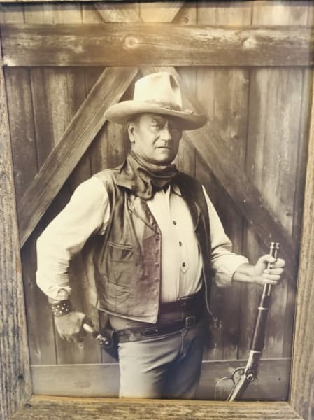 An old-timey photo of famous tough guy and cowboy John Wayne dons the saloon-style walls at Granzin Bar-B-Q. (Ian Pribanic/Community Impact Newspaper)