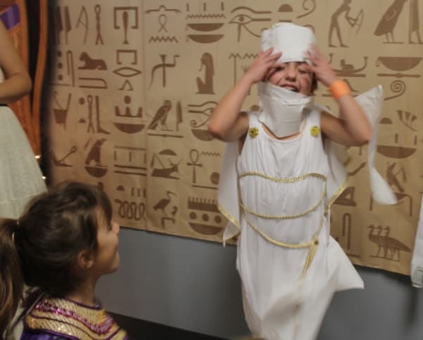 first-grade student Ashley Laskowski breaks out of her bandages during the Egyptian feast. (Brian Perdue, Community Impact Newspaper)