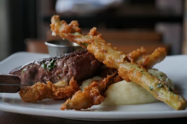 The 8-ounce filet ($28) is served with kabayaki compound butter, piene sauce, tempura asparagus, wasabi soy and garlic whipped potatoes. (Gavin Pugh/Community Impact Newspaper)