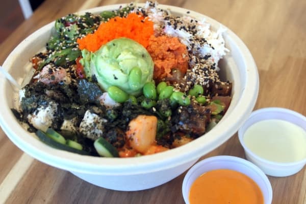 Poke Bowl offers two sizes of bowls with either three scoops of protein or four. Customers can choose from unlimited toppings.