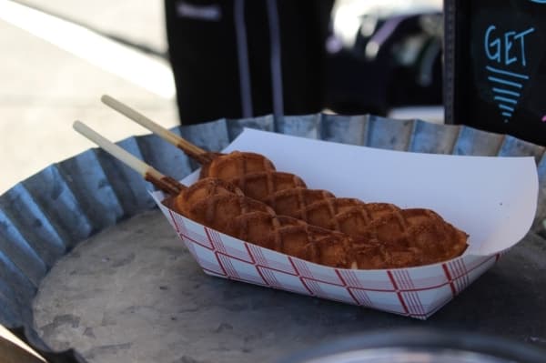 Customers can purchase waffles on a stick at the farmers market. (Anna Lotz/Community Impact Newspaper)