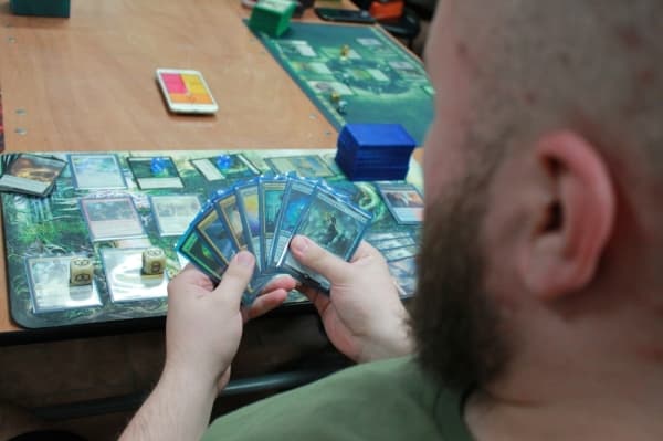 Wesley Ulloa looks at his cards during a game night at Ettin Games. (Andy Li/Community Impact Newspaper)