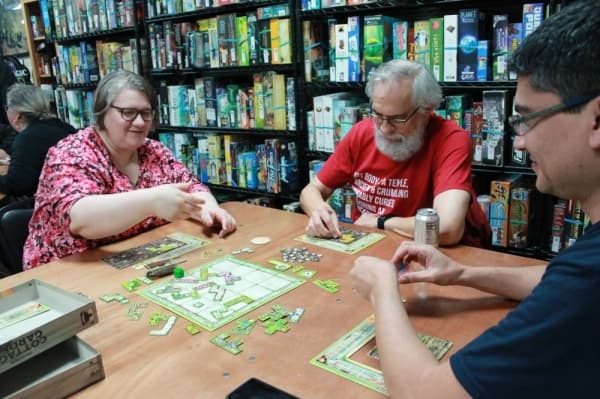 From left: Kim Lucas, Dave Steup and Edward Gorzek play Cottage Garden. (Andy Li/Community Impact Newspaper)