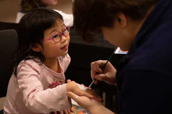 Katie Xu, five, gets a unicorn painted on her hand in the kids area of the Rec Fest kickoff event at Carpenter Park Recreation Center. (Liesbeth Powers/Community Impact Newspaper)