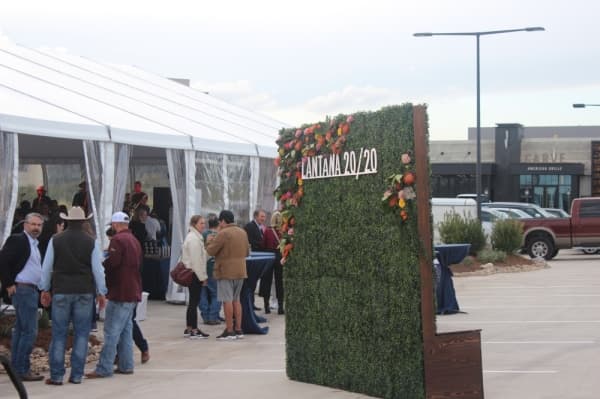 A photo of a photo-op backdrop beside a tent. The backdrop reads "Lantana 2020."