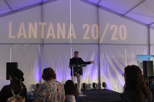 A photo of a man speaking at a podium.