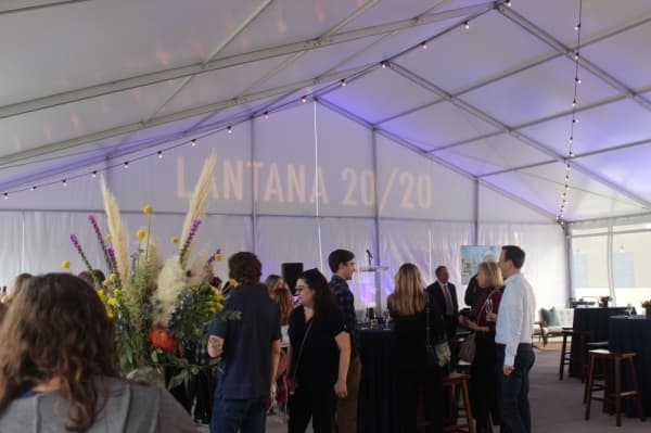 A photo of the interior of tent with a soiree in full swing.