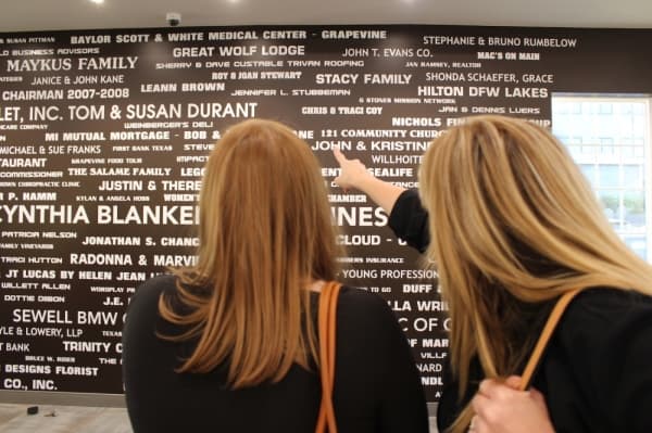 A wall painted with the names of project donors features prominently on one side of the room. (Renee Yan/Community Impact Newspaper)

