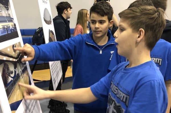 Students examine the designs for the new gymnasium. (Andy Li/Community Impact Newspaper)