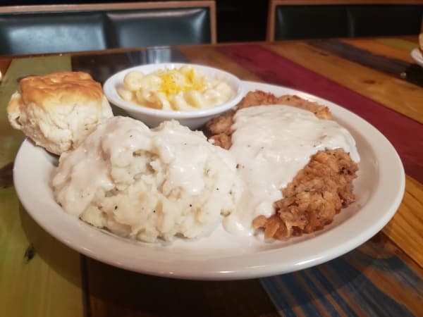 Chicken-fried steak with steak seasoned in a special blend, hand battered and fried, served with homemade gravy, mashed potatoes, macaroni and cheese, and a biscuit ($10.29)