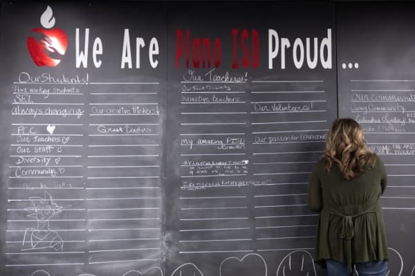 Guests of the diversity celebration stop to fill in the blanks on the large chalk stand in the common area of Williams High School. (Liesbeth Powers/Community Impact Newspaper)