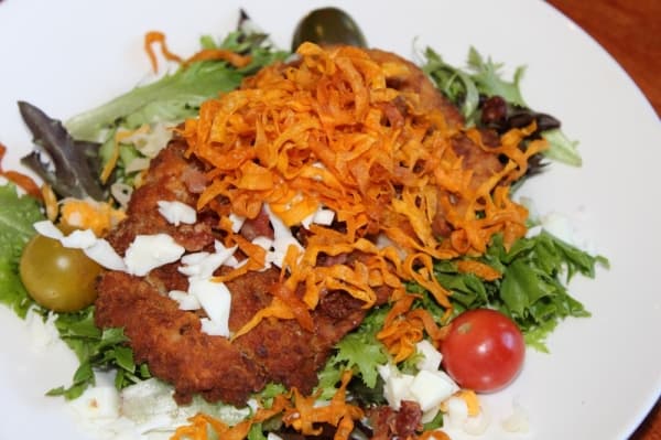 Diners with dietary restrictions can order gluten-free options, such as the Macadamia Club Salad ($14). (Renee Yan/Community Impact Newspaper)