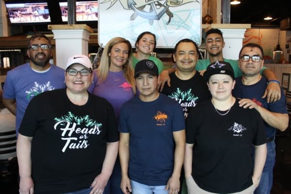 Owner Brittney Aplin (second from left, middle row) opened Captain Brad’s Coastal Kitchen in January 2019 in honor of her father, Brad. (Kara McIntyre/Community Impact Newspaper)