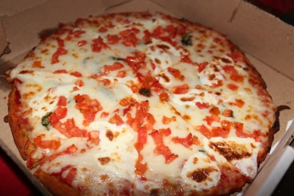 Margherita Pizza ($13.99 for 10 inches) is topped with fresh mozzarella cheese, cherry tomatoes, fresh basil and tomato sauce and drizzled with olive oil.
