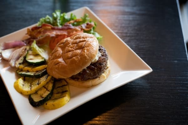 Kobe beef burger ($12.95): A half pound of beef is topped with melted gorgonzola, caramelized onions, bacon, lettuce and tomato on a butter bun and served with grilled vegetables.