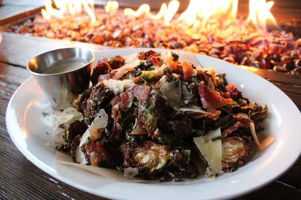 Owner Dave Coussirat said the crispy brussel sprouts ($11) are a customer favorite. They are topped with a white balsamic vinaigrette, shaved parmesan, bacon and fried sage. (Photo by Anna Herod/Community Impact Newspaper)